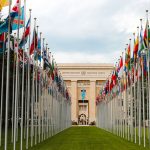 Bandeiras de diversos países em frente à entrada da sede da ONU em Genebra.