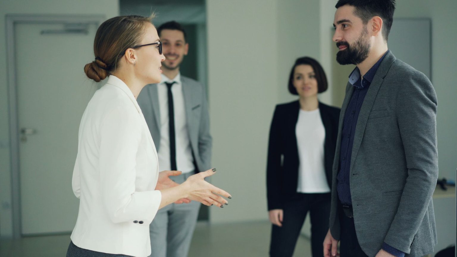 Grupo diverso de profissionais participa de uma reunião de trabalho em um ambiente corporativo.