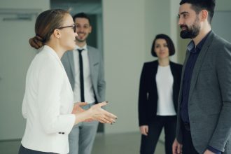 Grupo diverso de profissionais participa de uma reunião de trabalho em um ambiente corporativo.